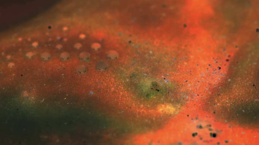 Bubbling and flowing orange and green liquid