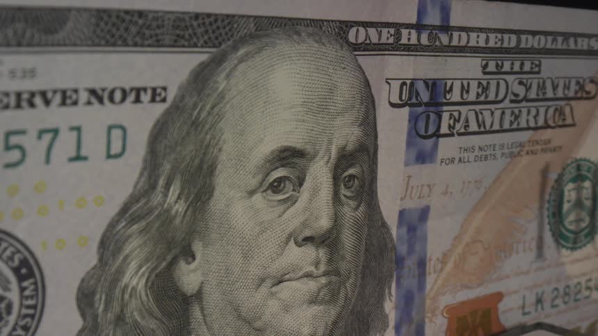 Extreme close up of a one hundred dollar bill on a black background