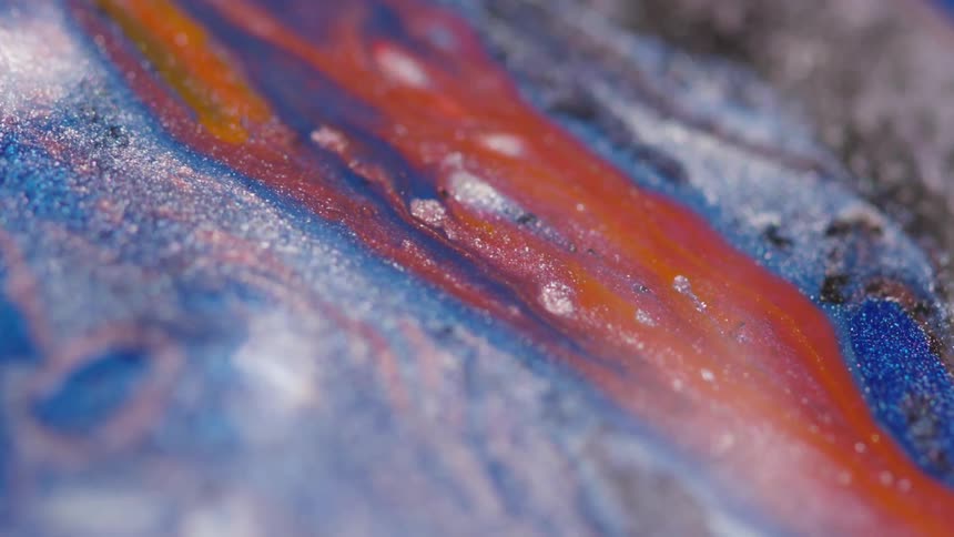 Flowing red and blue liquid with glitter