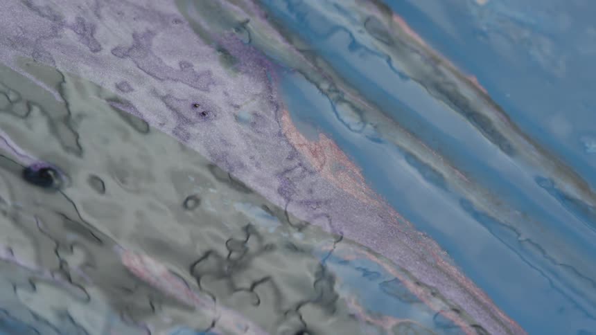 Liquid paint mixing together on artwork