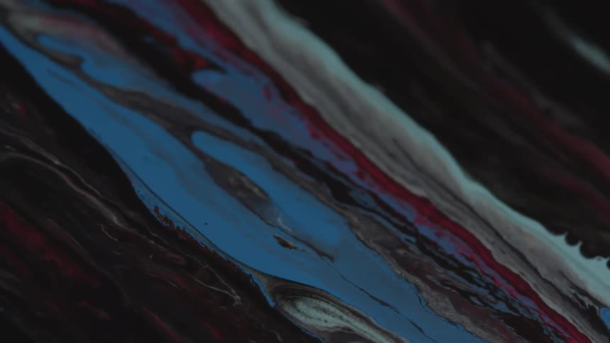 Red white blue and black paint flows across surface