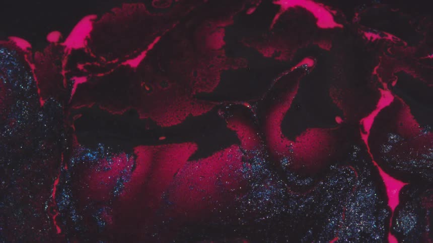 A close up of black particles in front of a red background