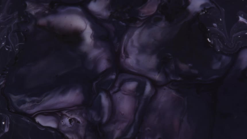 White paint and purple dye mix together to form patterns