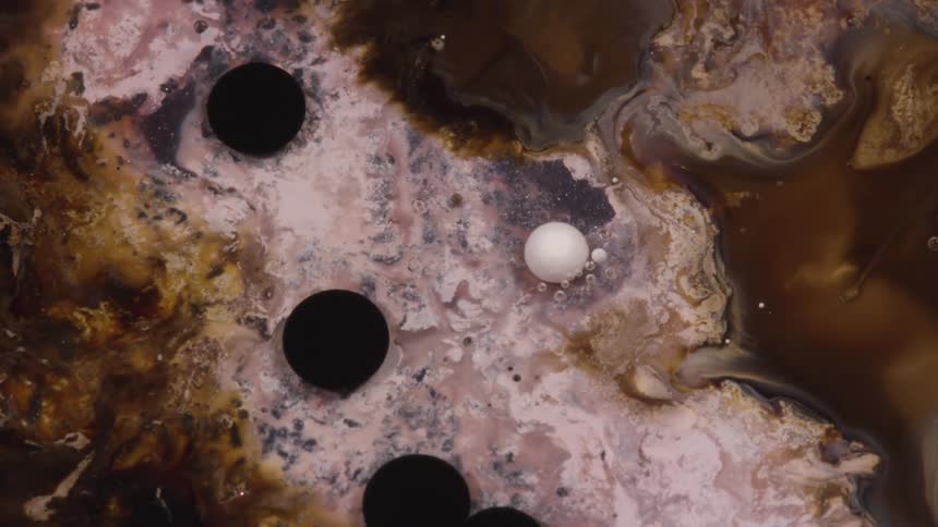 Mixture of creams and browns burst into black circular areas