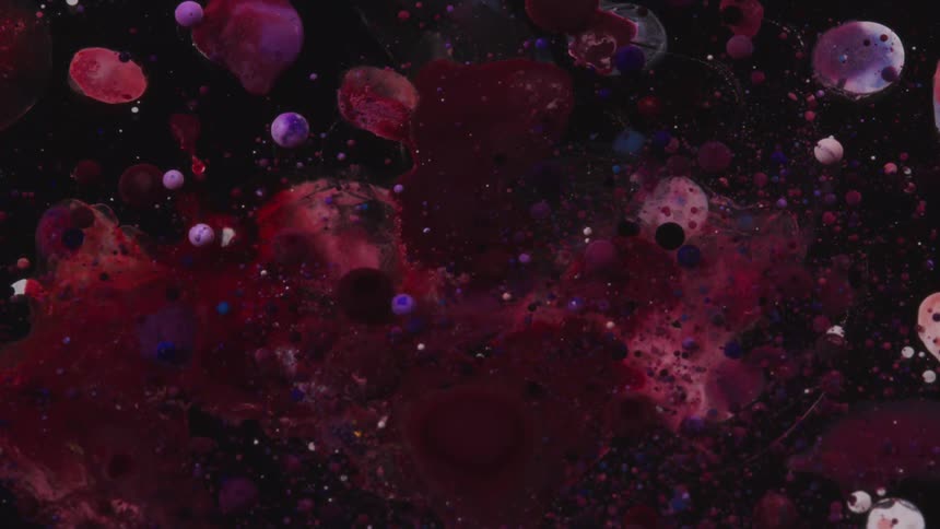 Purple and red droplets suspended in liquid