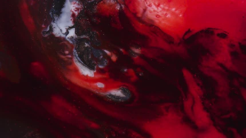 Swirling black red and white liquid