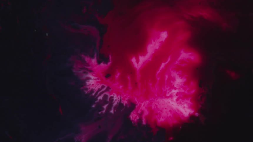 A bright red liquid flows in the middle of black liquid