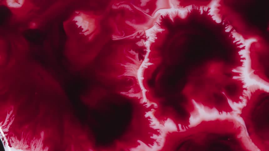Red paint spreads on the white surface