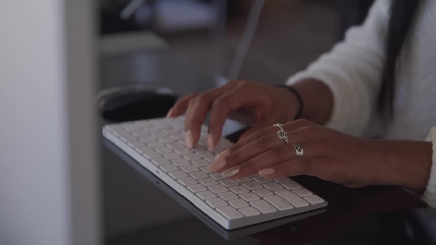 Woman typing on computer keyboard