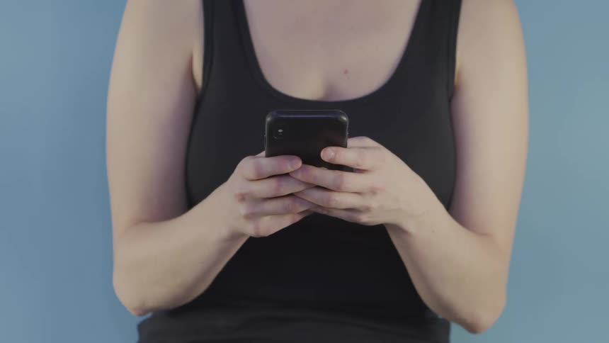 A woman types on a cell phone and then makes a phone call