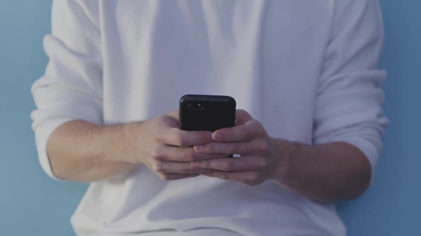 A man is texting on a cellphone