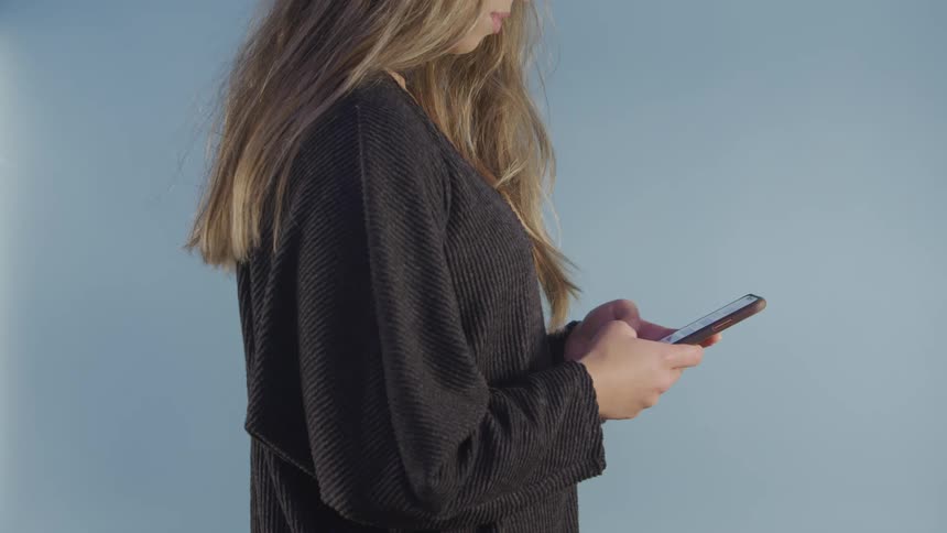 Blonde woman in grey long sleeve shirt texts on mobile phone then makes call