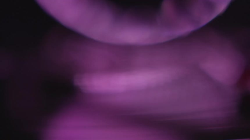 Out of focus shimmering violet lights reflections in the dark