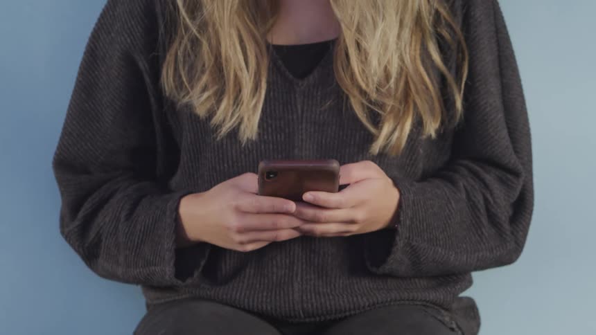 A woman is texting on a cell phone