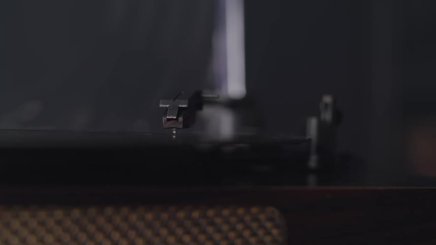 A person turns on a turntable to play a vinyl record