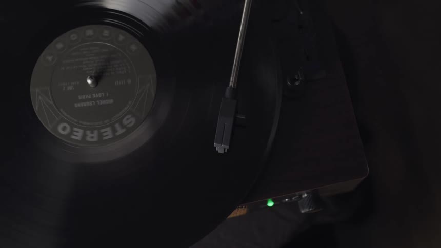 A record spinning on a record player with a needle and lights