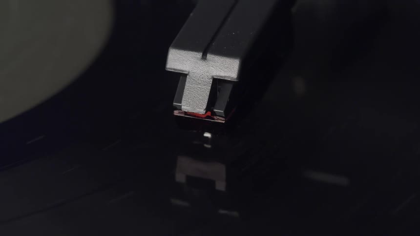 Tone arm of a turntable playing a vinyl record