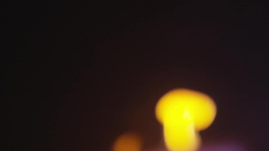 In the darkness of night a flame can be seen burning in the distance