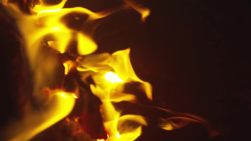 A fire is burning outdoors at night
