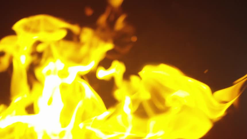Close up of yellow flames on a fire at night
