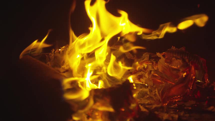 Debris is on fire outdoors at night