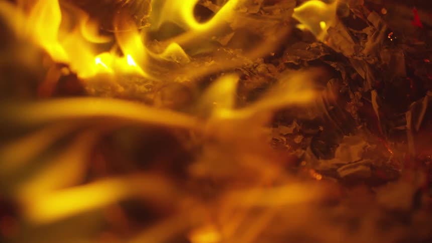 A fire is burning outdoors at night