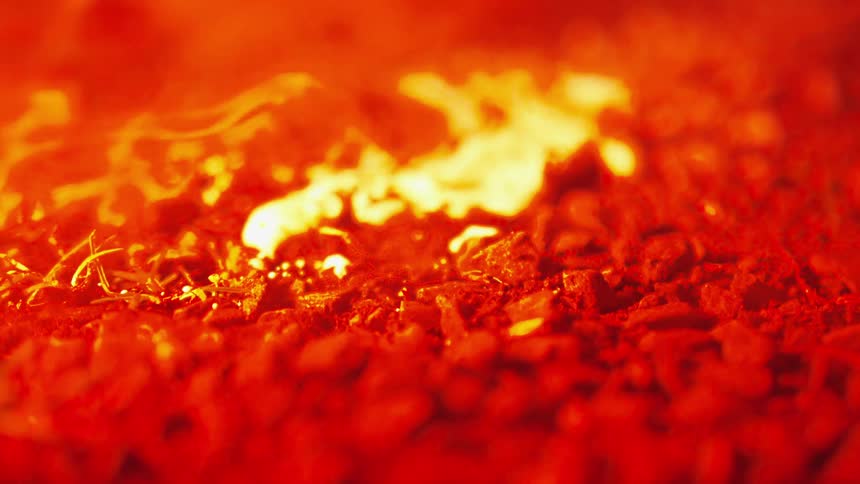 Orange and yellow smoke floating over gravel