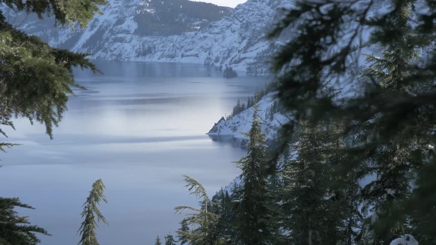 A mountain lake surrounded by pine trees on a winter day
