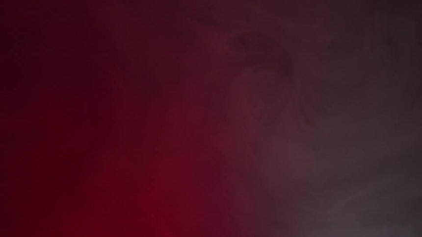 Different shades of red and pink combine with smoke to form swirl patterns