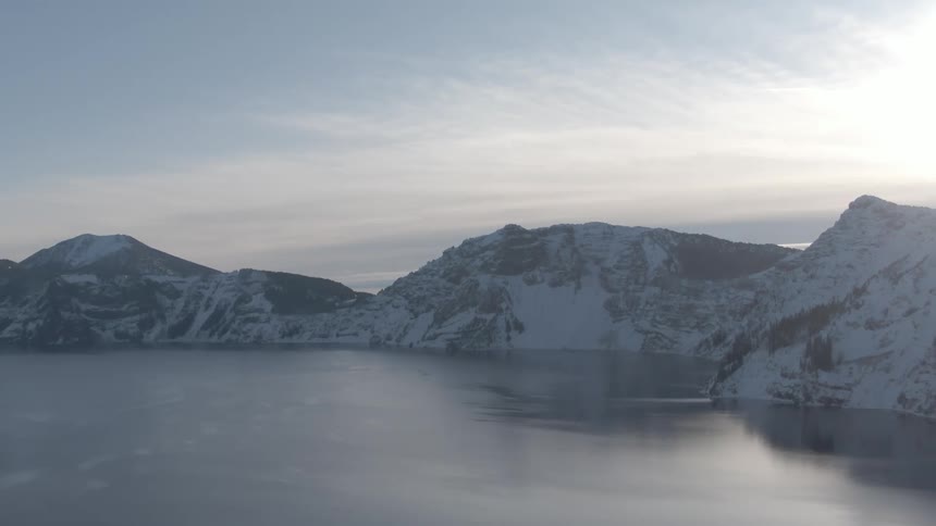 Landscape view of snow covered mountains surrounded by water