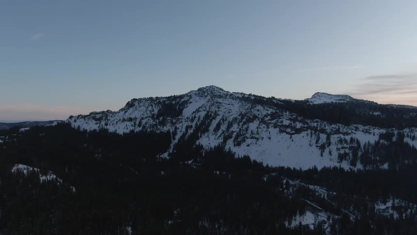 A snowy mountain range at dawn