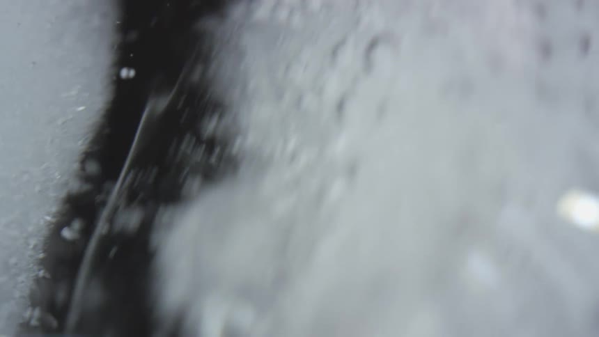 Extreme close up of ice cubes floating on the surface of a drink