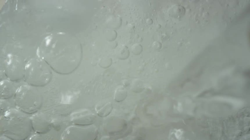 A clear liquid is poured over some ice cubes