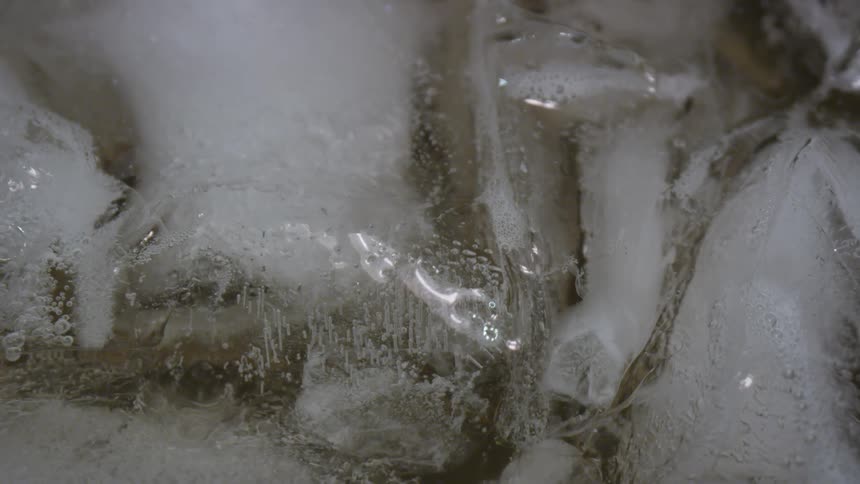 Ice cubes fill and rise to the top of a glass