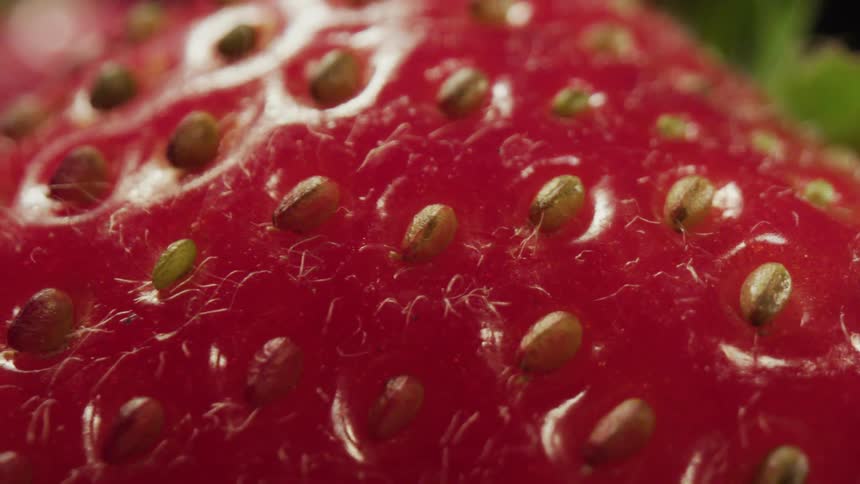 Close up of a strawberry withbrown seeds on its surface