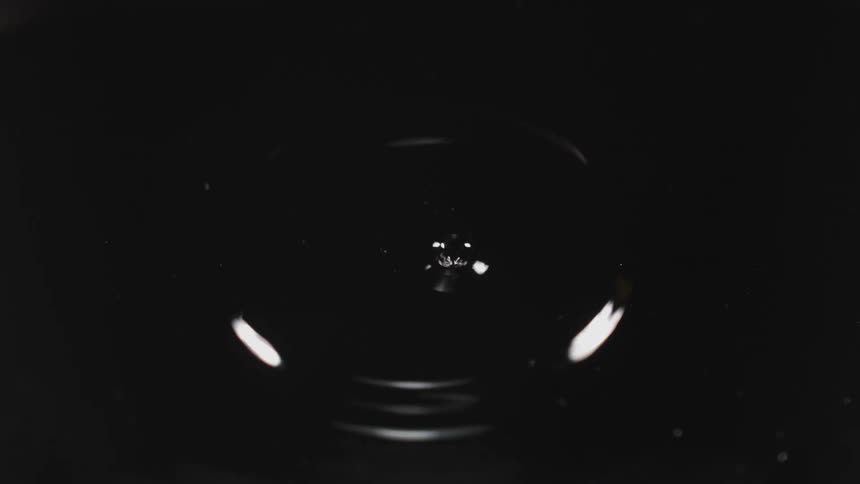 A drop falls into a calm liquid
