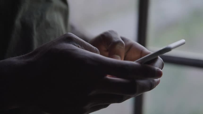 A man is texting on a smartphone