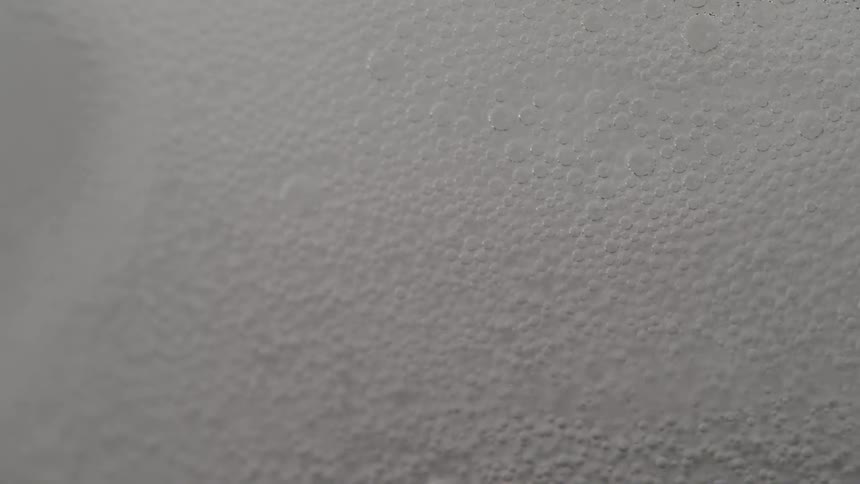 Soda water is poured over ice creating bubbles