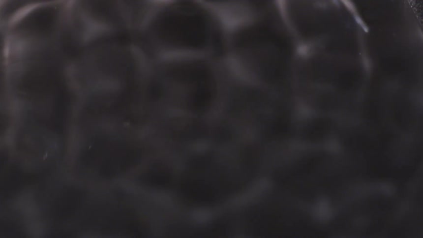A black liquid forms a pattern resembling honeycomb
