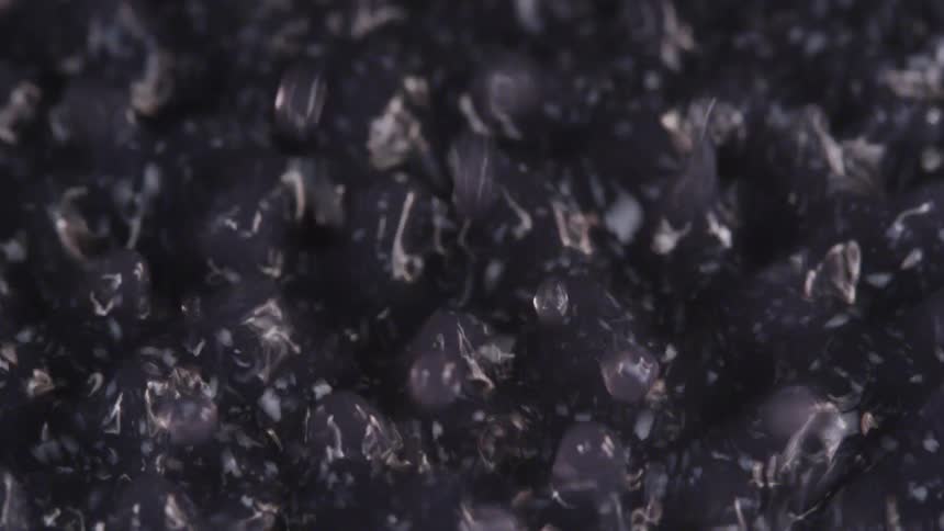 The surface of a dark liquid has countless small ripples dancing across it