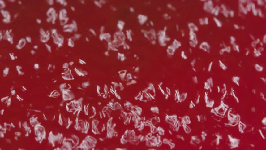 Glass shards bounce around red surface
