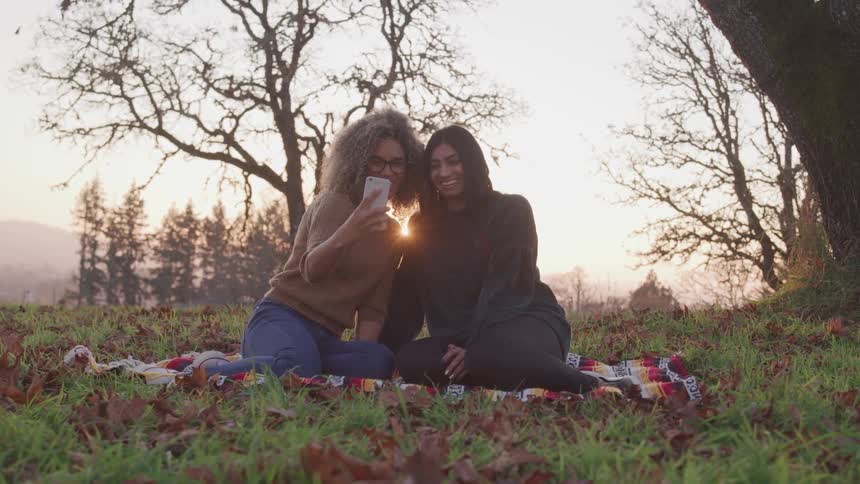 Two women take a selfie at a picnic