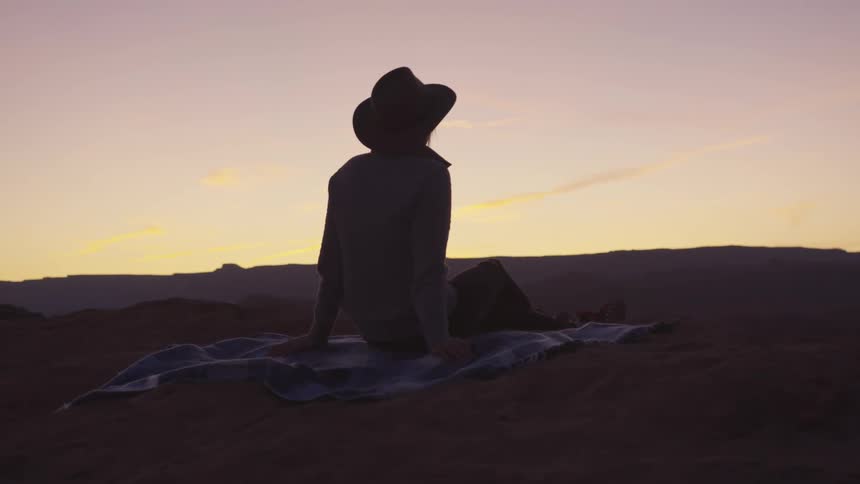 A woman sits and looks at the landscape