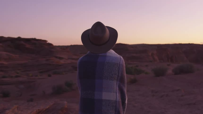 A woman is walking outdoors at sunset