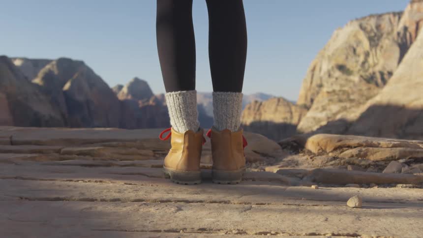 A woman is standing on a mountain