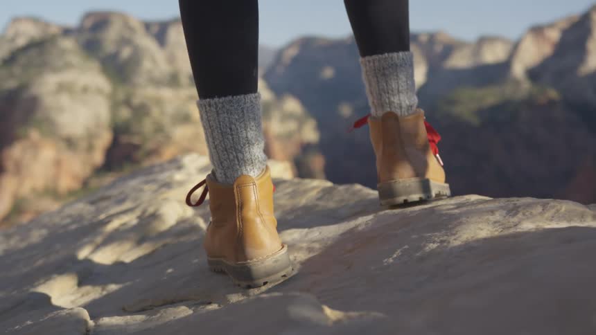 A person is standing on the cliff of the mountain range