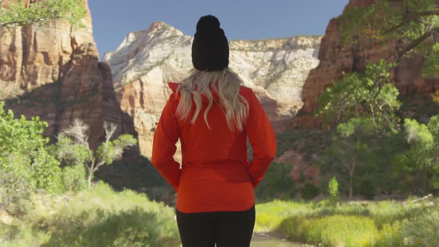 A woman is hiking near the mountains