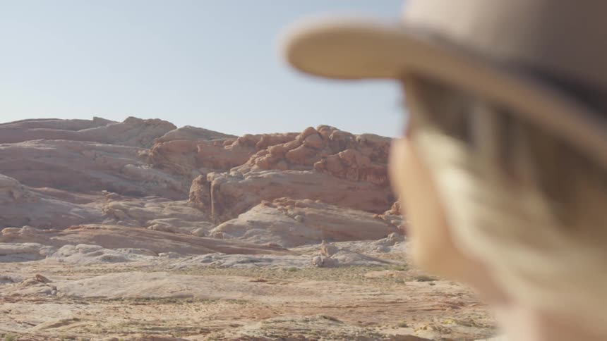 A woman is standing outdoors by a canyon