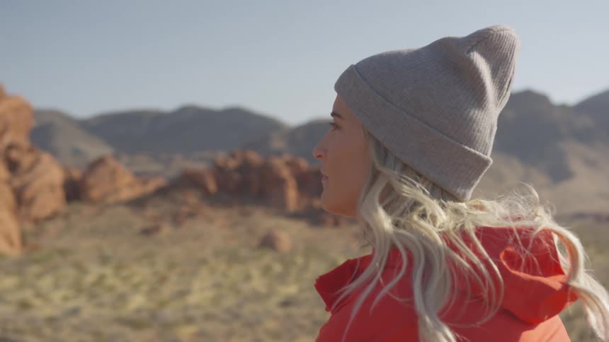 Young woman sitting in front of desert landscape