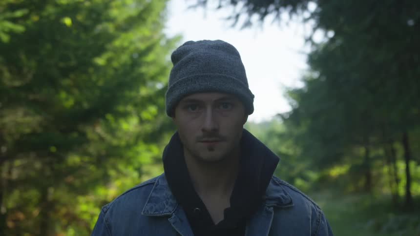 A man is outdoors in a wooded area